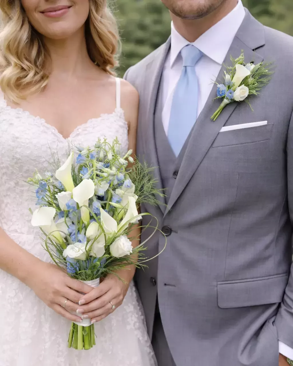 White calla lily and blue delphinium bridal bouquet with matching groom's boutonniere