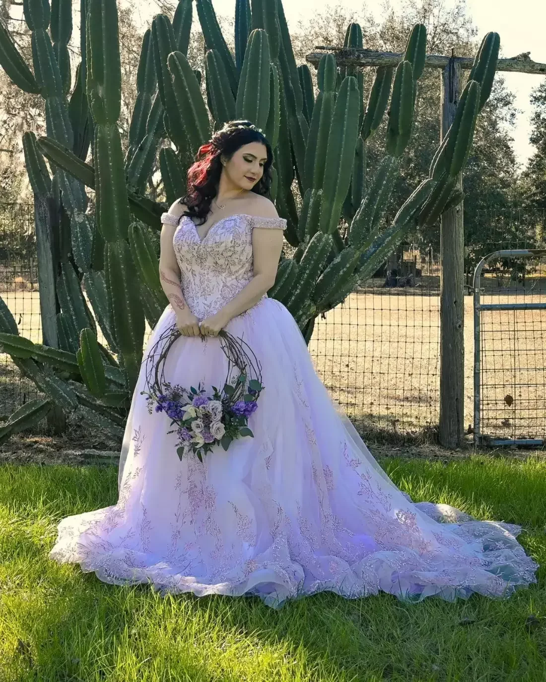 Bride holding a unique hoop bouquet of lavender and purple flowers at a rustic Florida ranch wedding