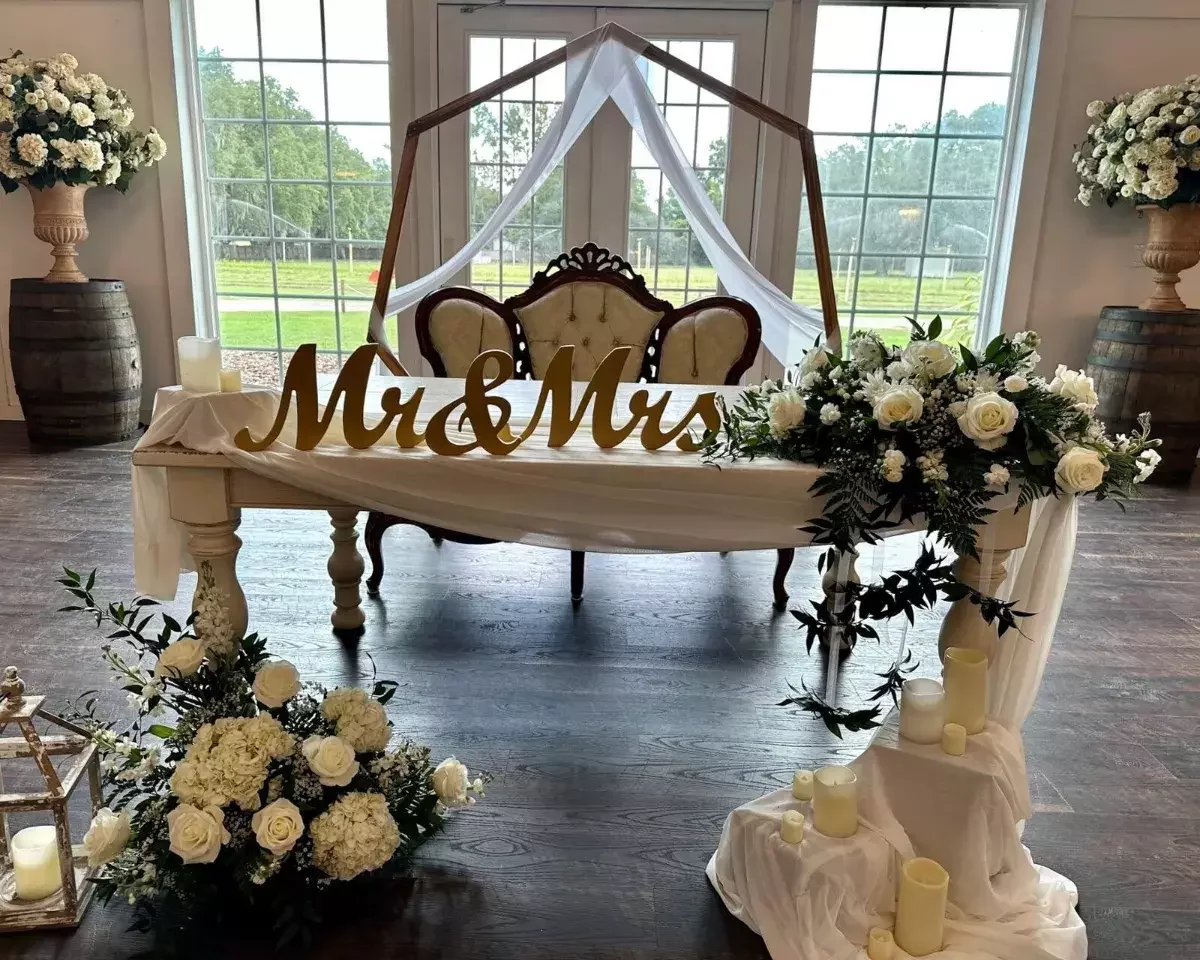Mr and Mrs sweetheart table with white and green florals at Ever After Farms wedding venue